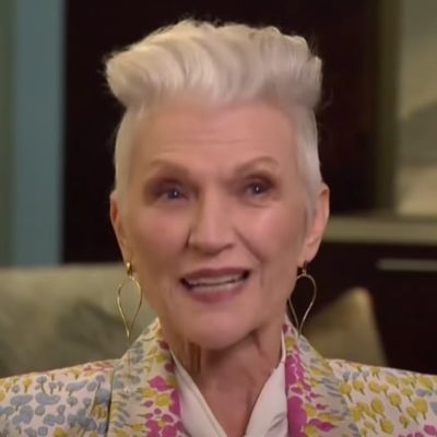 Maye Musk can be seen having a short hair wearing bright clothes in the picture.
